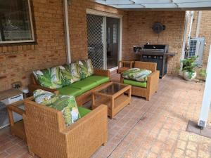 a patio with couches and a table and a stove at Coastal play and stay - walk to beach and park in Toowoon Bay