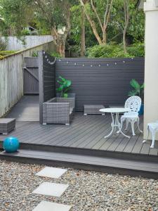 a wooden deck with a table and chairs on it at Riverstone Retreat Upper Hutt in Upper Hutt