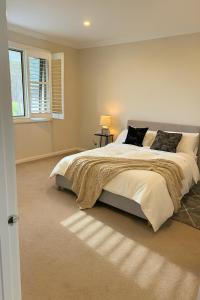 a bedroom with a large bed and a window at Hampton Luxe Designer Retreat with Park Views in Melbourne