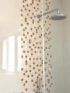 ein Bad mit einer Dusche und einer Fliesenwand in der Unterkunft Hampton Luxe Retreat 4BR Pet Friendly in Melbourne