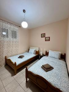 a bedroom with two beds and a window at Tzelak Village House in Palaiomonástiron