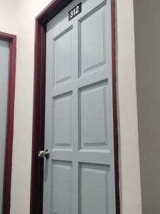 a white door with the number on it at BENUTHOMEStay in Benut