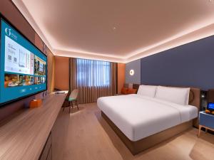 a bedroom with a bed and a flat screen tv at Orange Hotel Shenzhen Nanshan Subway Station in Shenzhen +13 photos