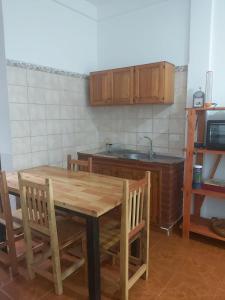 a kitchen with a wooden table with chairs and a sink at DON MIGUEL DEPARTAMENTOS in Puerto Iguazú