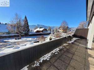 ein schneebedeckter Hof mit einem Zaun und einem Haus in der Unterkunft Apartments in Bad Mitterndorf - Steiermark 41123 in Bad Mitterndorf