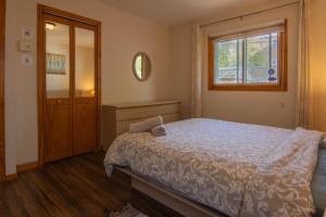 a bedroom with a bed and a window and a mirror at Cozy bungalow near Montreal and shops in Longueuil +15 photos