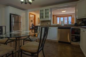 a kitchen with a table and chairs and a refrigerator at Cozy bungalow near Montreal and shops in Longueuil