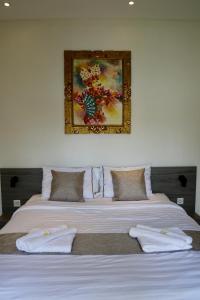 a bedroom with two beds and a painting on the wall at Villa Dylia with private pool in Panji