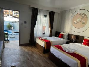 una camera d'albergo con due letti e una piscina di Avenue Hotel VangVieng a Vang Vieng Altre 31 foto