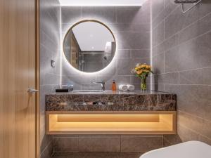 a bathroom with a sink and a mirror at Orange Hotel Shenzhen Nanshan Subway Station in Shenzhen