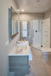 a bathroom with a sink and a shower and a toilet at Swiss-Belsuites Victoria Park Auckland in Auckland