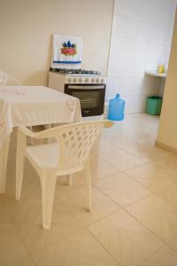 cocina blanca con mesa y fogones en apartamento Completo Localização Excelente Centro, en Canindé