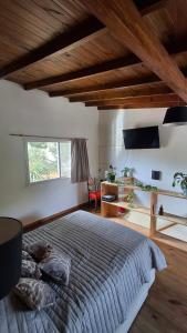 Un dormitorio con una cama y un escritorio y una ventana. en Casa Saint Claire, en Santa Clara del Mar