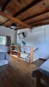 Un dormitorio con paredes blancas y techo de madera. en Casa Saint Claire, en Santa Clara del Mar