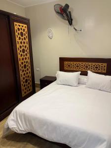 ein Schlafzimmer mit einem großen weißen Bett mit zwei Kissen in der Unterkunft Spirit valley villa in Luxor