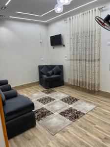 ein Wohnzimmer mit einer schwarzen Couch und einem Fernseher in der Unterkunft Spirit valley villa in Luxor