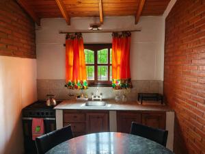a kitchen with a table and a sink and a window at Complejo Fresia in Mina Clavero