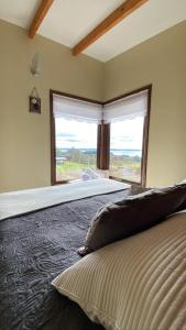 拉戈朗科Cabañas Las Terrazas De Iculpe的一间带大床和大窗户的卧室