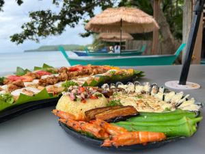 a plate of food on a table with shrimp and vegetables at The Bangka Beach Guesthouse in Siquijor