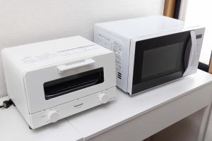 a microwave and a toaster oven sitting on a counter at Entire Villa, 2-Min to Beach, near Enoshima Island in Fujisawa
