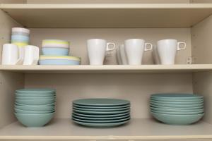 a shelf filled with plates and cups and bowls at Entire Villa, 2-Min to Beach, near Enoshima Island in Fujisawa