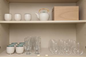a shelf with glass jars and vases on it at Entire Villa, 2-Min to Beach, near Enoshima Island in Fujisawa