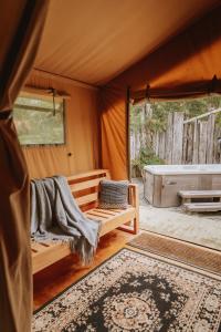 Una habitación con cama y bañera en una tienda en Raglan Rural Retreats - Rimu Tent, en Raglan