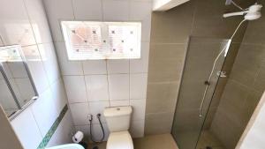a bathroom with a shower and a toilet and a window at Pousada da Lua Barretos in Barretos