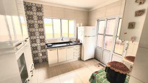 a kitchen with white cabinets and a white refrigerator at Pousada da Lua Barretos in Barretos +7 photos