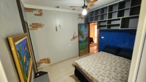 a bedroom with a bed and paintings on the wall at Pousada da Lua Barretos in Barretos