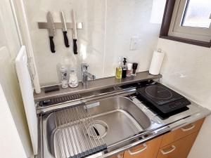 a small kitchen with a sink and a stove at Toya Tiny Cabin 洞爺タイニーキャビン in Lake Toya +10 photos
