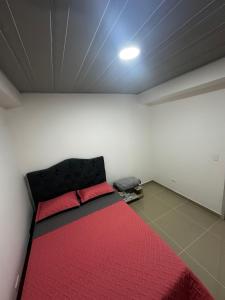 a bedroom with a bed with a red comforter at 302 Villamaria in Pereira