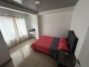 a bedroom with a bed with a red blanket at 302 Villamaria in Pereira
