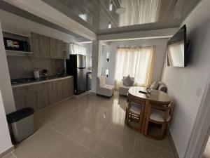 a living room with a table and a kitchen at 302 Villamaria in Pereira