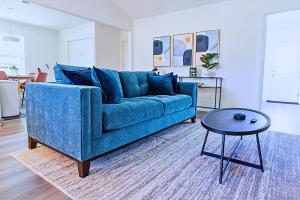 a living room with a blue couch and a table at Plano 40 miles to Fifa Stadium Private Pool Lux Home by Vacation Your Way in Plano