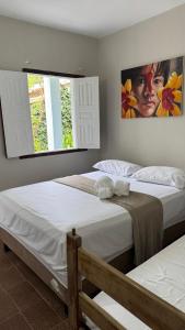 阿拉亚尔达茹达Recanto D'Ajuda的有两张床和一扇窗户的卧室