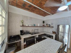 een keuken met een aanrecht en een koelkast bij Tayau Bungalows B3 in Lo de Marcos