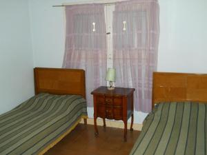 a bedroom with two beds and a table with a lamp at Chalet céntrico super cómodo in Miramar