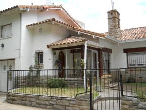 a white house with a fence in front of it at Chalet céntrico super cómodo in Miramar