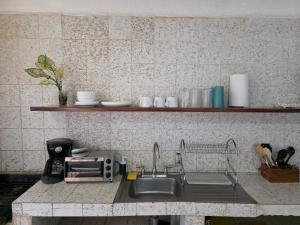 een aanrecht met een spoelbak en een magnetron bij Tayau Bungalows B3 in Lo de Marcos