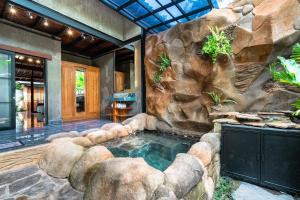 Una casa con una piscina pequeña en una pared de roca. en Peaceful 1BR Private Villa in Sayan Ubud, en Ubud