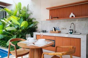 Una cocina y un comedor con mesa y sillas. en Three Brothers Munggu Suites Villas and Restaurant, en Pererenan
