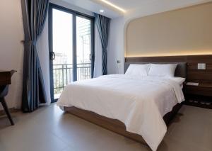 胡志明市Lumia Hotel的一间卧室，配有一张大床和一扇大窗户。