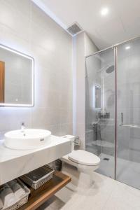 胡志明市Lumia Hotel的浴室里有马桶、洗手池和淋浴。