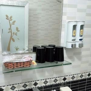 estante en el baño con espejo y cepillos de dientes en Phương Thảo Hotel - Near Noi Bai Airport, en Kon Rung (1)