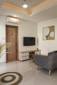 un soggiorno con divano e TV a schermo piatto di Giegie Villa a Tanah Lot