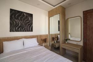 a bedroom with a bed and a large mirror at Giegie Villa in Tanah Lot +14 photos