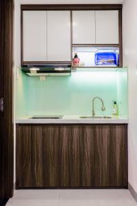 胡志明市Lumia Hotel的配有木制橱柜和水槽的厨房