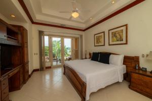 1 dormitorio con 1 cama con ventilador de techo y TV en Bella Vista 3A 3BR Ocean View, en Isla Herradura