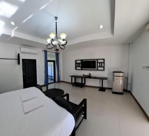 a room with a bed and a table and a tv at Vang Vieng Moment Resort in Vang Vieng